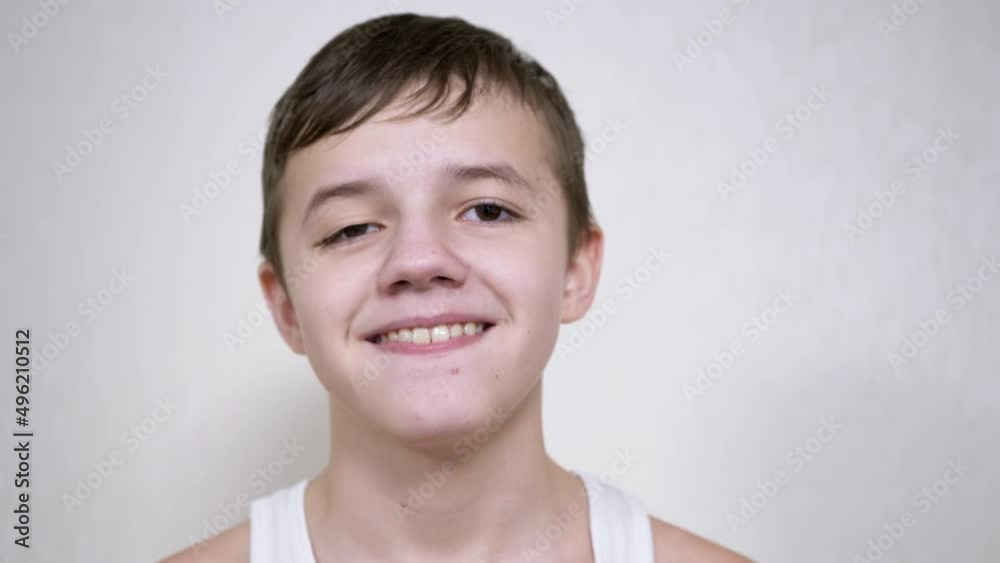 Smiling Teenager Gesticulates with Mouth, Showing his Teeth, Tongue