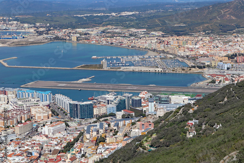 Panoramic view over Gibraltar harbour from the top of the Rock of Gibraltar. The airport runway juts out into the water. © Anthony