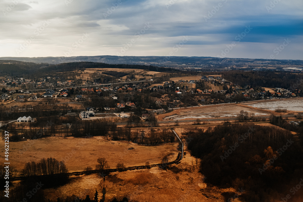 Fototapeta premium View of the city and mountains from above from a drone and an airplane. Cities aerial view, sky and clouds