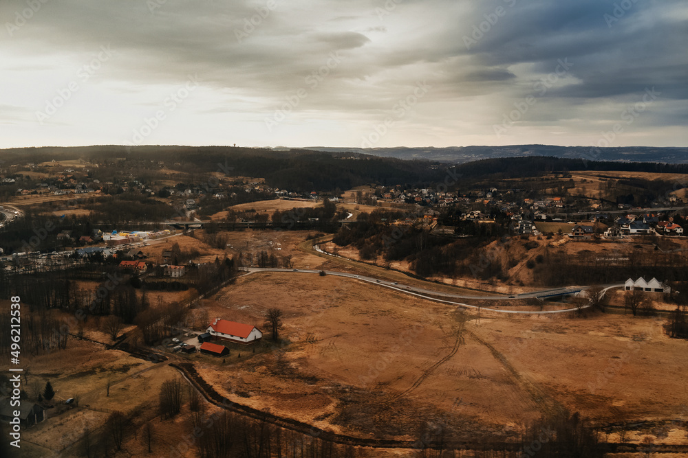 Fototapeta premium View of the city and mountains from above from a drone and an airplane. Cities aerial view, sky and clouds
