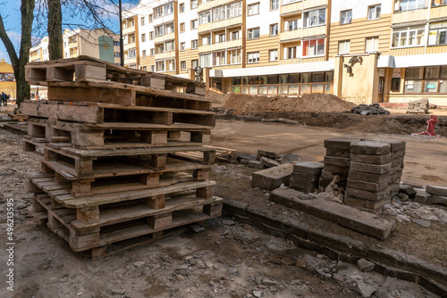 Old worn-out wooden pallets at a construction site in the city. Repair of the city street and sidewalk. © Pokoman