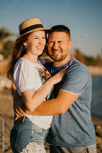 a man and a woman in love laughing hug on the beach. newlyweds at the resort.  © andrey