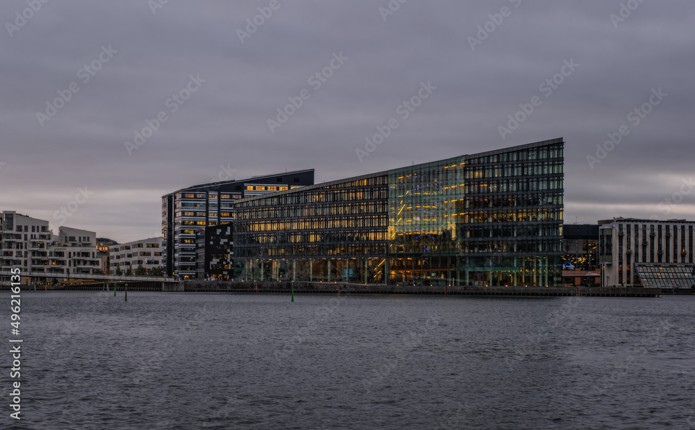 Aller Media AS headquarters, futuristic dark building on Havneholmen in Copenhagen at sunset, Denmark on November 2021. Designed by PLH Architects. Overcast day and almost monochrome image. Aller Media AS headquarters, futuristic dark building on Havneholmen in Copenhagen at sunset, Denmark on November 2021. Designed by PLH Architects. Overcast day and almost monochrome image.