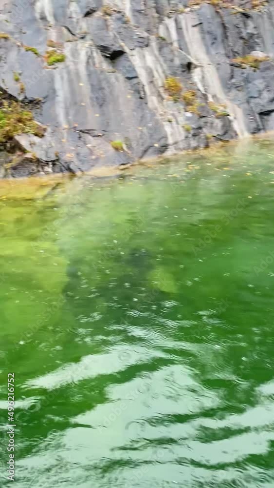 Clear mountain lake in rainy weather. Small circles on the river surface from raindrops. Boat tour of rocky canyon filled with water. Beautiful nature. Clear mountain lake in rainy weather. Small circles on the river surface from raindrops. Boat tour of rocky canyon filled with water. Beautiful nature.
