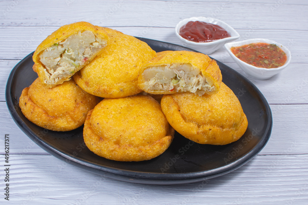 Traditional Colombian snack, chicken empanada with hogao, lemon and sauce