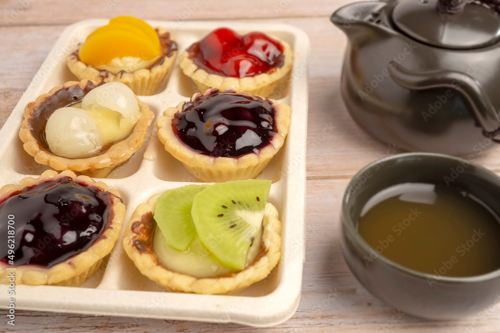 Homemade Fruits tarts, Sweet desserts topping with fresh kiwi, blueberries, peach, longan, raspberries in syrup, served with hot herbal tea on wooden table
Homemade Fruits tarts, Sweet desserts topping with fresh kiwi, blueberries, peach, longan, raspberries in syrup, served with hot herbal tea on wooden table