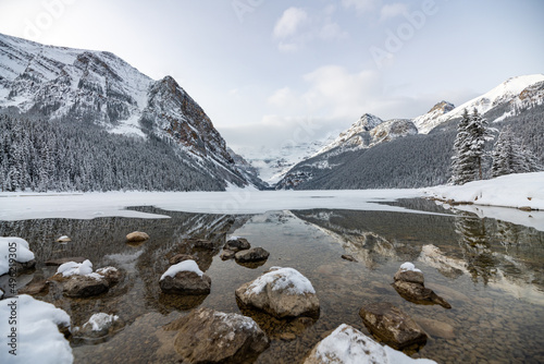 Iconic Lake Louise in Banff National Park during winter time with reflection in water. 