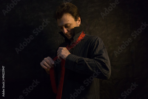 Retrato de hombre joven con ropa de vestir, camisa oscura y corbata roja. Bodegón. Naturaleza muerta. © Galdys V