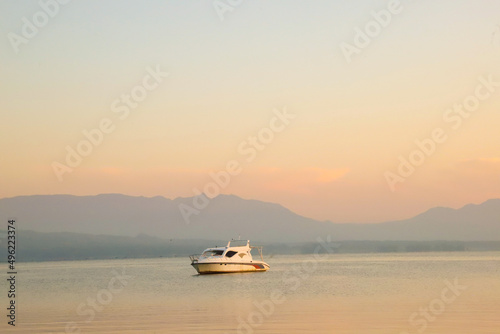 Lake Toba Background with Ship at sunrise with golden clouds © Accountanz