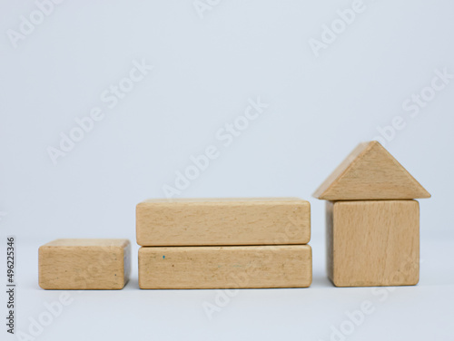 Fototapeta Naklejka Na Ścianę i Meble -  stairs made of wooden cubes with a house on top. investment insurance and home purchase mortgage real estate concept
