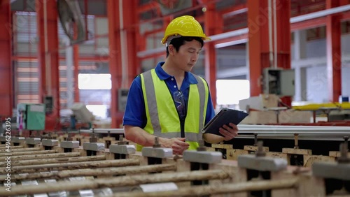 Supervisors or employees within the factory are walking to check the work of the machines within the factory, checking and checklist of machines to be in a ready-to-use condition
