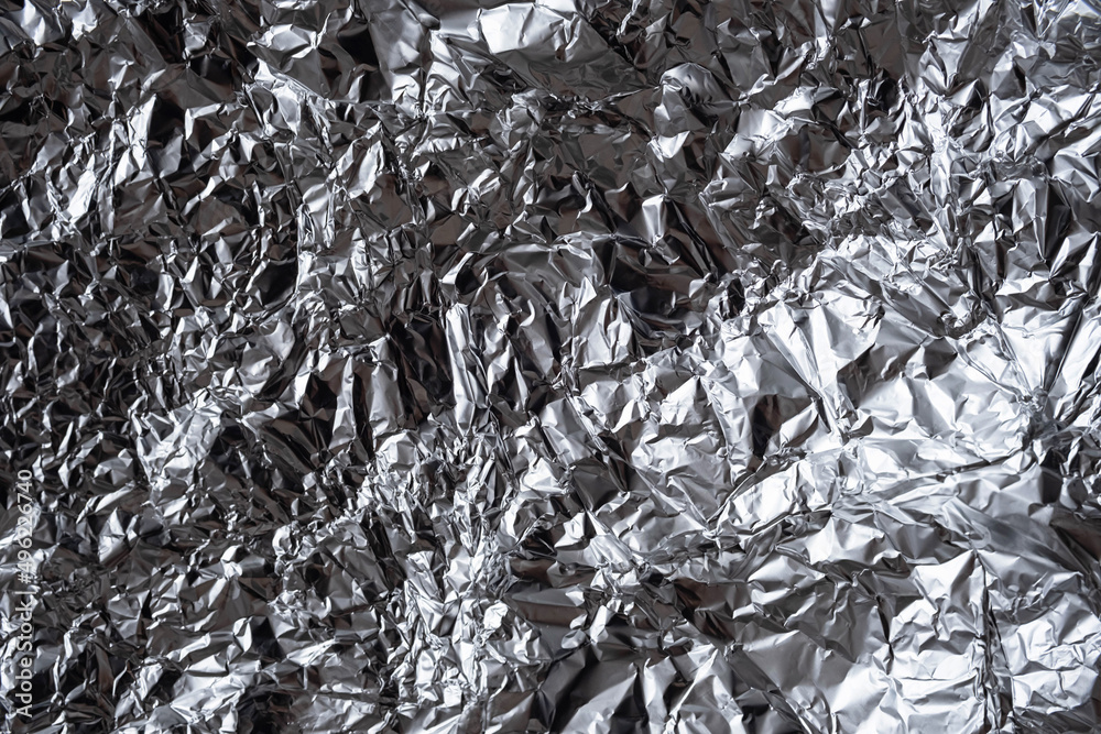 Abstract crumpled silver foil background. Shiny rumpled foil sheet texture. Abstract crumpled silver foil background. Shiny rumpled foil sheet texture.
