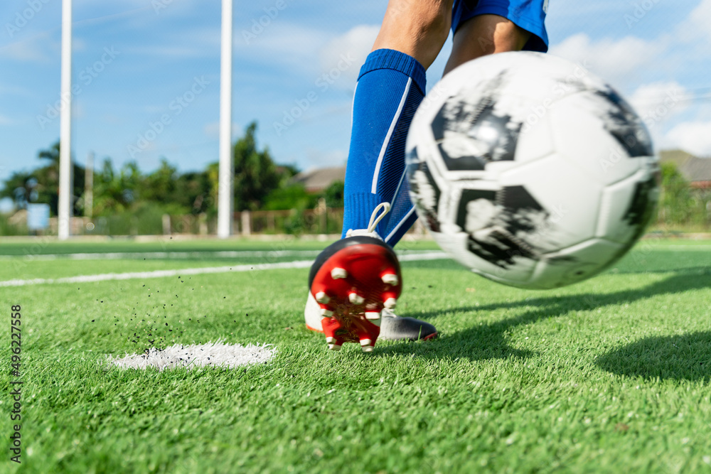 Close-up football or soccer on soccer field. man holding ball on sky  background. close up of futsal shoes. fitness concept. football is all  about motion. soccer player kick football. Stock Photo