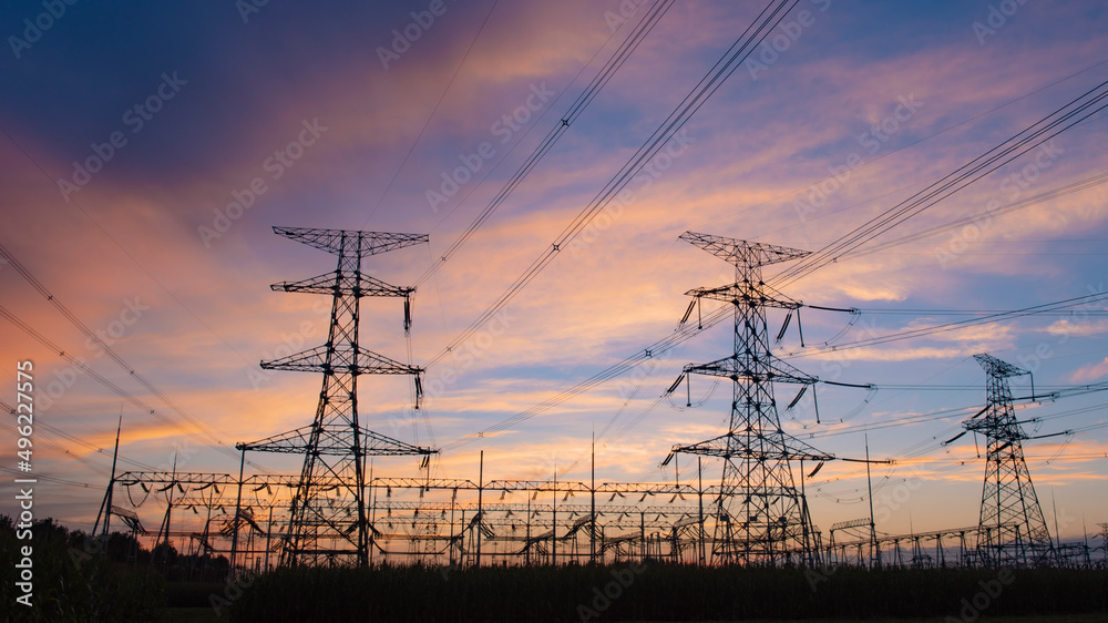 A silhouette of an electric tower against a beautiful sunset background