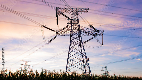 A silhouette of an electric tower against a beautiful sunset background