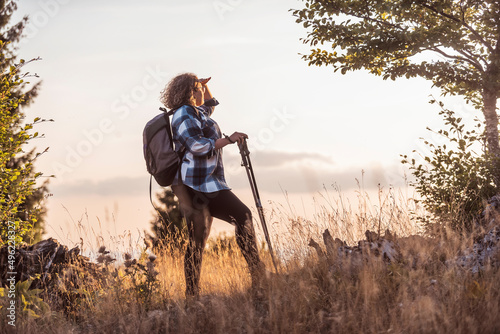 A photo of a woman hiking with a backpack. Selective focus
