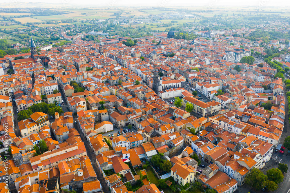 Aerial view of residential area of Riom town with similar brownish roofs in summer, Auvergne, France