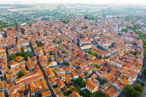 Aerial view of residential area of Riom town with similar brownish roofs in summer, Auvergne, France