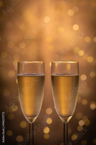 Champagne glasses over holiday bokeh blinking background, glasses with sparkling wine, celebration, party