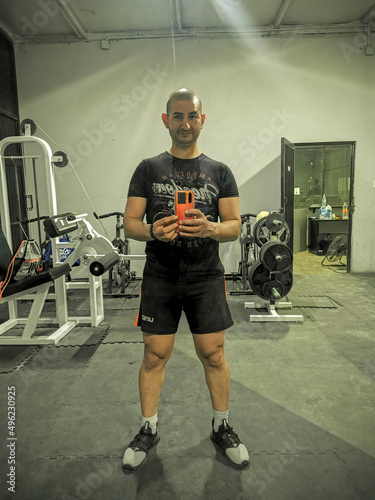 hombre en el gym, haciendo ejercicio, levantando pesas photo