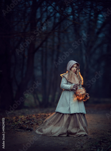 Girl with lantern in a dark night forest