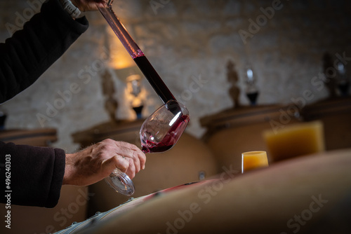 FRANCE, GIRONDE, SAINT-EMILION, SAMPLING A GLASS OF WINE IN A BARREL WITH A PIPETTE FOR TASTING AND VINIFICATION MONITORING, HIGHT QUALITY PHOTO