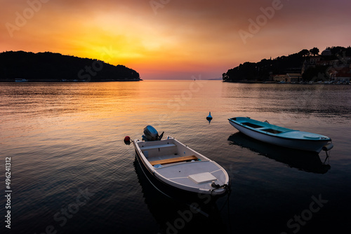 Fishing boats in a sea, near coast. Sunset time.