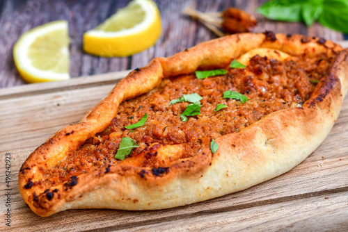  Traditional Turkish cuisine. Baked Pide dish with  cheese and  herbs on  wooden background.  Turkish pizza pide photo