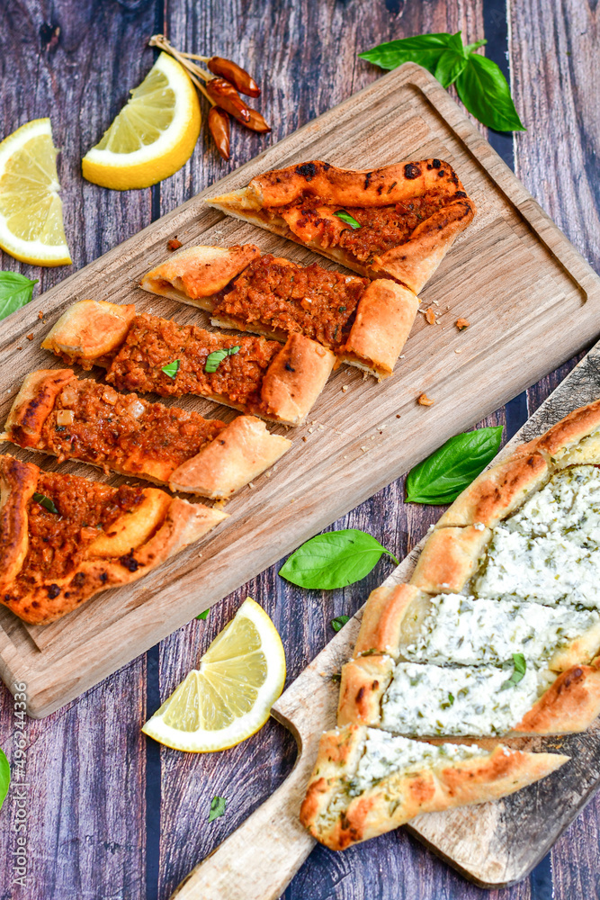 Traditional Turkish cuisine. Baked Pide dish with minced beef, tomatoes and cheese on wooden background. Turkish pizza pide Traditional Turkish cuisine. Baked Pide dish with minced beef, tomatoes and cheese on wooden background. Turkish pizza pide