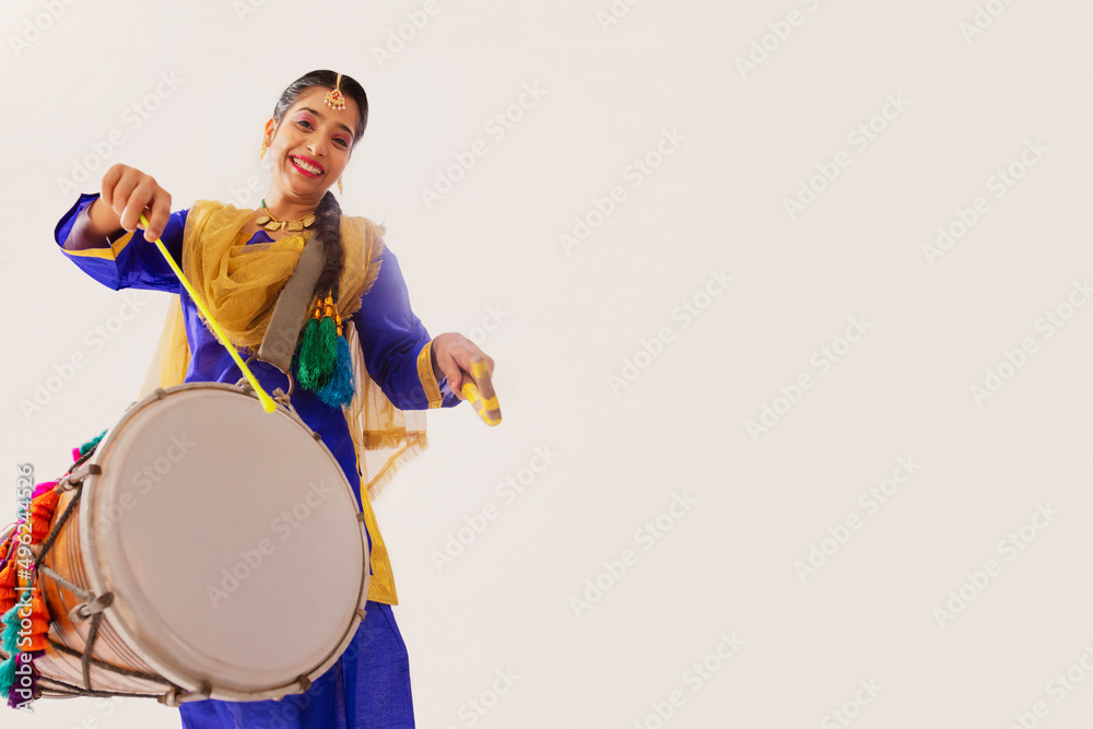 Portrait of Sikh woman playing drum during Baisakhi celebration Portrait of Sikh woman playing drum during Baisakhi celebration