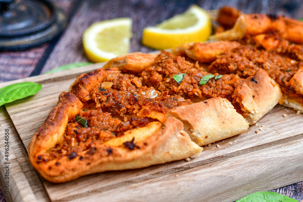 Traditional Turkish cuisine. Baked Pide dish with minced beef, tomatoes and cheese on wooden background. Turkish pizza pide Traditional Turkish cuisine. Baked Pide dish with minced beef, tomatoes and cheese on wooden background. Turkish pizza pide
