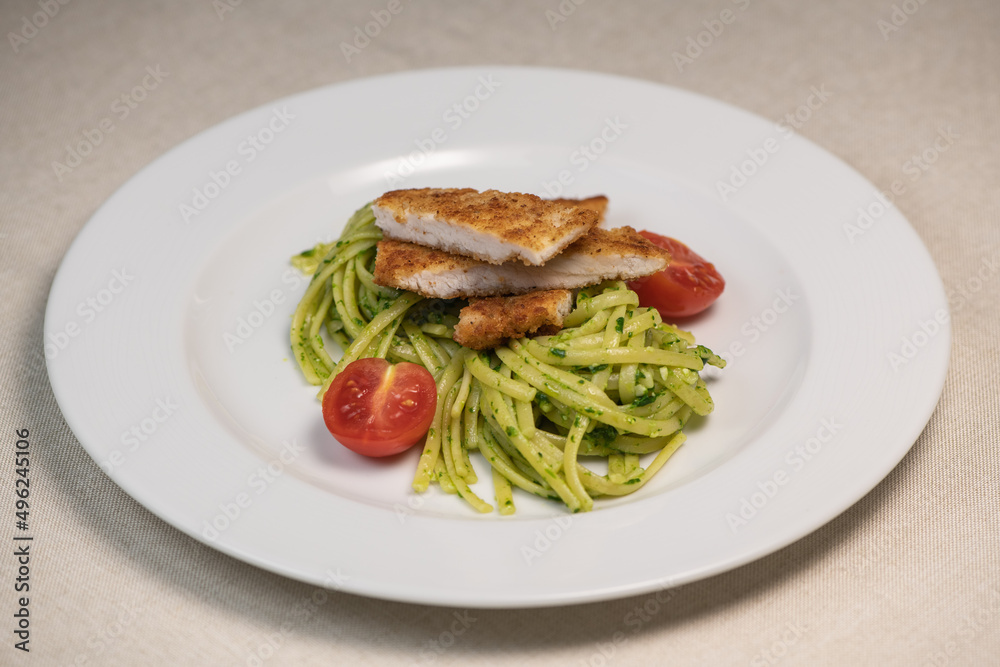 Turkey cutlet and Green spinach spaghetti with cheese and tomato on wooden table. High quality photo Turkey cutlet and Green spinach spaghetti with cheese and tomato on wooden table. High quality photo