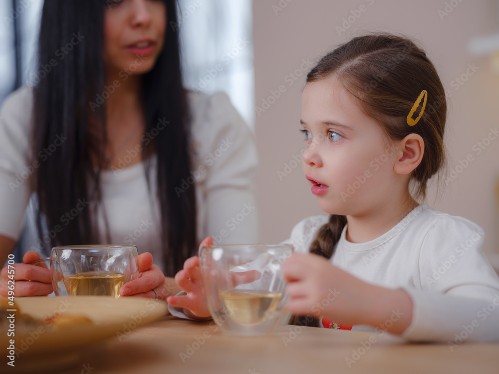 Family drinking tea with cookies on kitchen at home. Mother and daughter having fun, happy moment together at home. Family drinking tea with cookies on kitchen at home. Mother and daughter having fun, happy moment together at home.