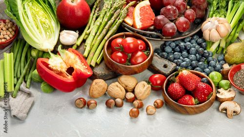 Delicious raw fruits and vegetables on light background.