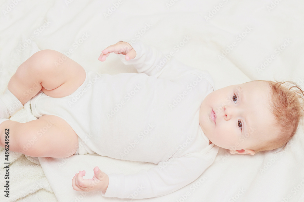 Happy child on the white blanket, blurred background Happy child on the white blanket, blurred background