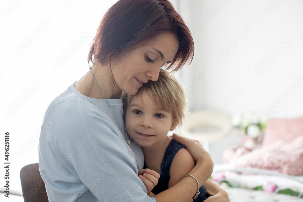 Portrait of mother and child, hugging on a back lit white background Portrait of mother and child, hugging on a back lit white background