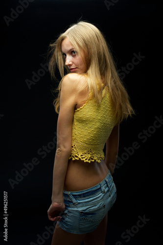 Young pretty woman with flower over black