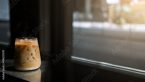 Ice coffee on table with cream being poured into it showing the texture and refreshing look of the drink