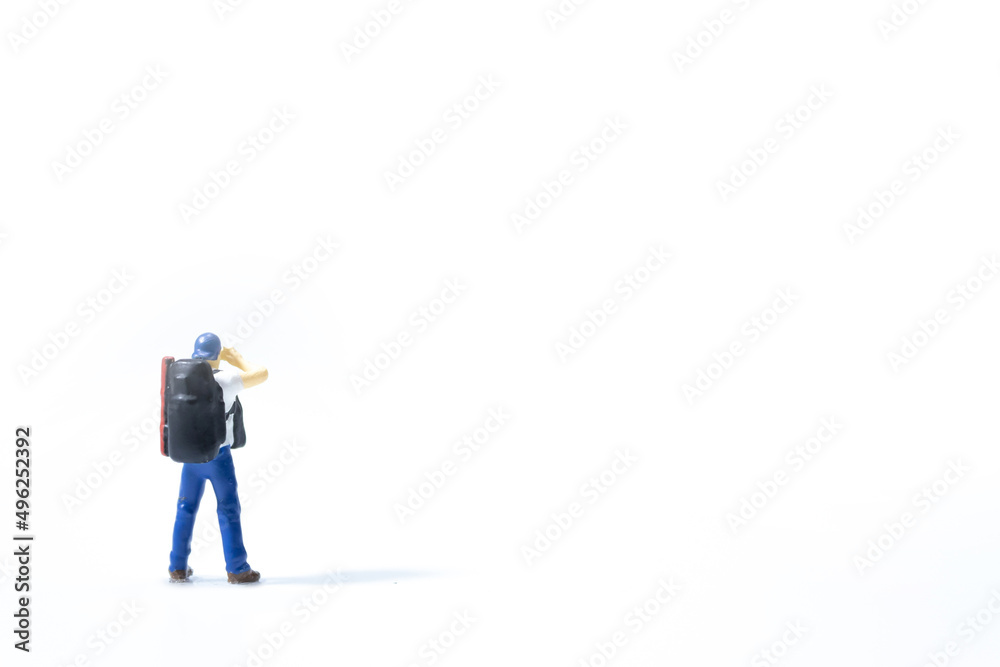 miniature traveler standing and looking for something on white background. miniature traveler standing and looking for something on white background.