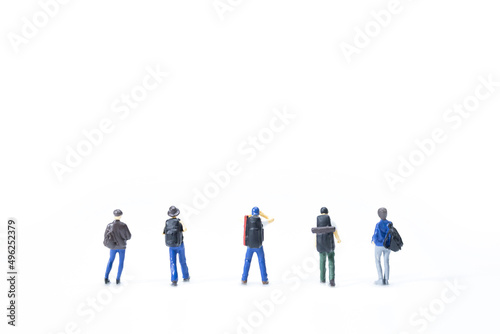 Group of miniature traveler standing on white background. © Yuan
