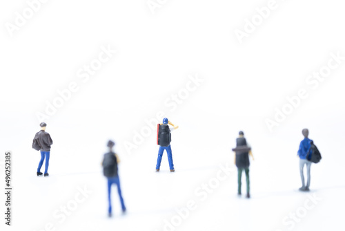 Group of miniature traveler standing on white background.