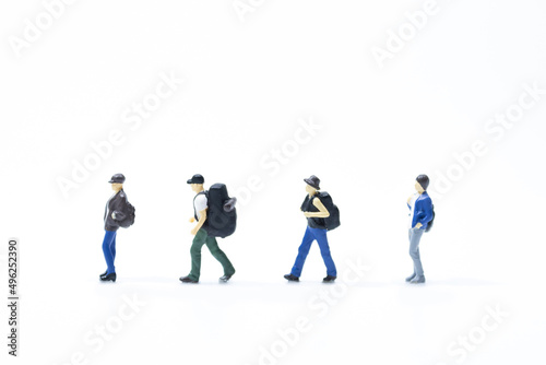 Group of miniature traveler line walking on white background.