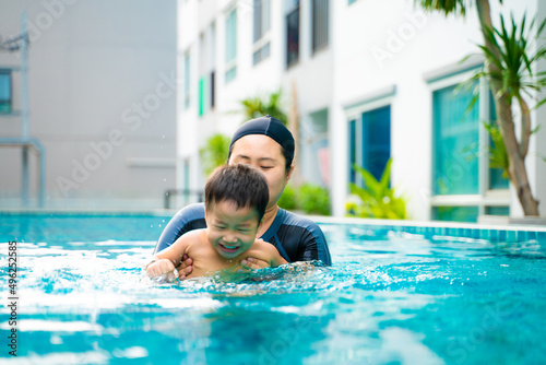 Mom with preschool sun swim in condominium swimming pool outdoor activity