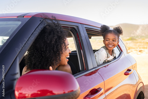 Fototapeta Mother and black daughter peeping outside car