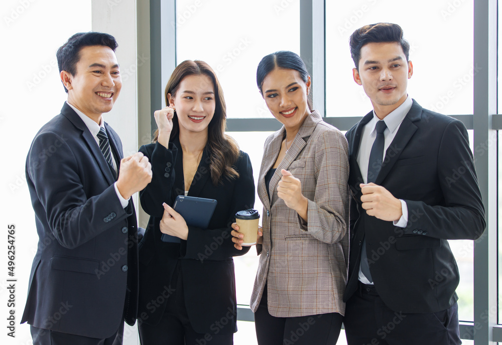 Group of young happy male and female professional successful businessman and businesswoman colleagues partnership in formal business suit standing rise fists up smiling celebrating job done together Group of young happy male and female professional successful businessman and businesswoman colleagues partnership in formal business suit standing rise fists up smiling celebrating job done together