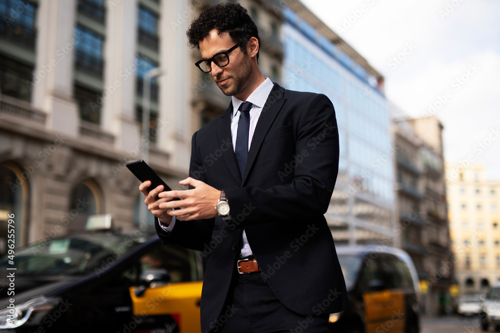 Handsome businessman using the phone. Young elegance man outdoors.
