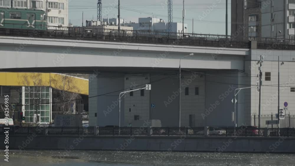 Cityscape of Moscow, Slow motion. The train of the city surface metro passes over the bridge over the river Cityscape of Moscow, Slow motion. The train of the city surface metro passes over the bridge over the river