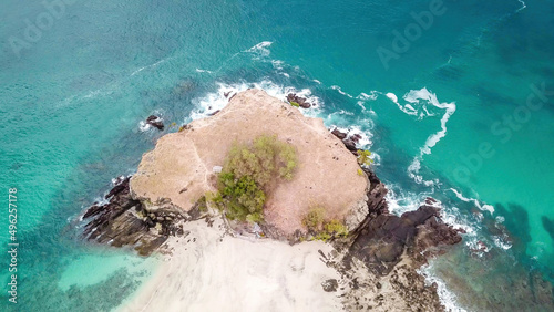 A top-down drone shot of an idyllic Koka Beach. Hidden gem of Flores, Indonesia. Headland going straight into the open sea. Beauty in the nature. Calm waves washing the cliff's slopes. Serenity. photo