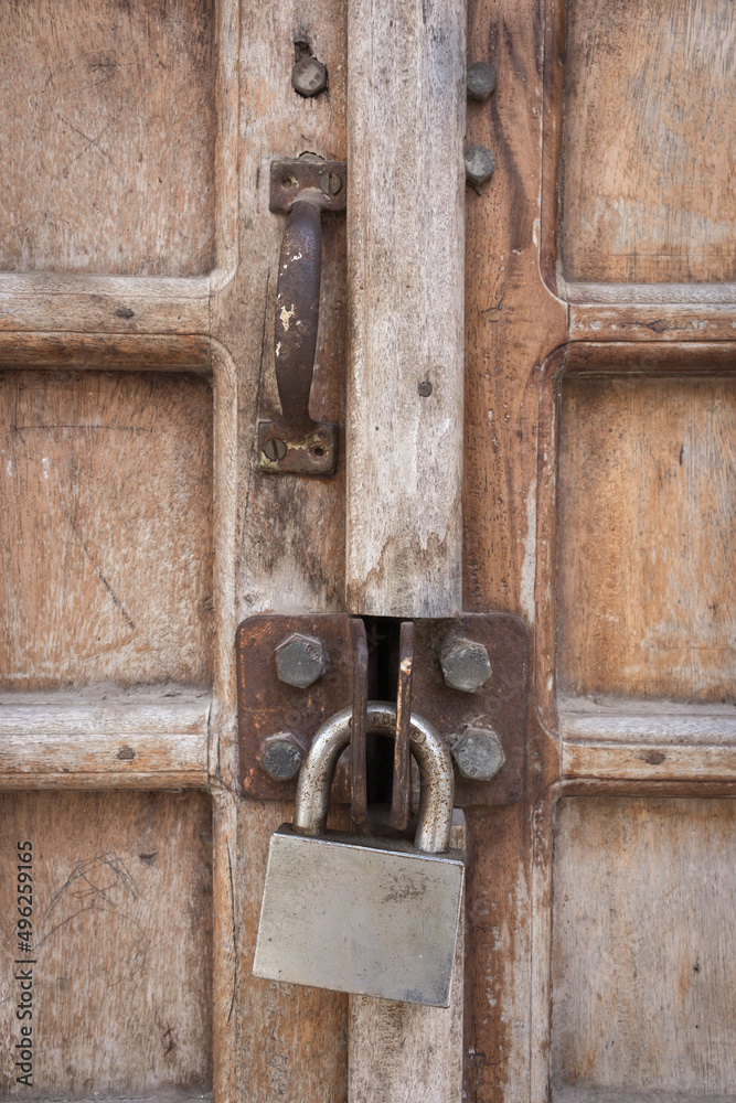 Ancient wooden door with iron padlock. Traditional door in Stone town, Zanzibar. Home security concept. Grunge old doorway with rusty lock. Weathered door with knocker. Closed home entrance. Ancient wooden door with iron padlock. Traditional door in Stone town, Zanzibar. Home security concept. Grunge old doorway with rusty lock. Weathered door with knocker. Closed home entrance.