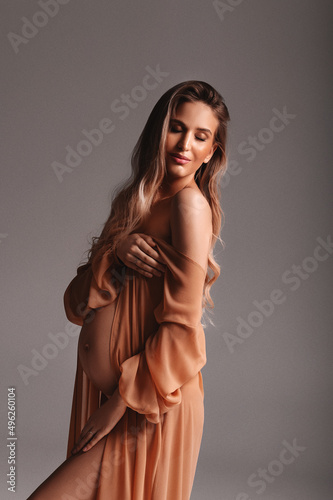 portrait of a woman in studio, the pregnant woman poses in the studio. beautiful pregnant blonde woman.